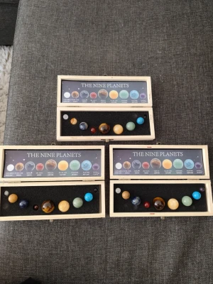Planetset med ädelstenar - 3 st Planetset nio planeter, där varje planet representeras av en ädelsten i olika färger och former. Planeterna är placerade i rad och levereras i en snygg trälåda med beskrivning av varje sten och planet. Perfekt för dig som gillar rymden.
