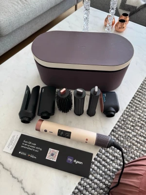 Dyson Airwrap multistyler med tillbehör - Säljer min fina Dyson Airwrap HS09 multistyler i beige och roséguld med flera stylingtillbehör och en snygg förvaringsbox i lila. Perfekt för att skapa lockar, volym eller slätt hår. Allt du behöver för att fixa frisyren hemma! Fick den i present men hade redan en sedan tidigare, därför är denna endast testad! 