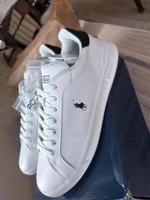 Vita Polo Ralph Lauren sneakers - Stilrena vita sneakers från Polo Ralph lauren.                Helt nya aldrig använda, ligger kvar i orginalkartong