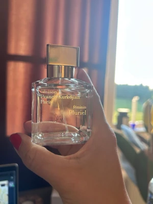 Maison Francis Kurkdjian Pluriel 70ml - Maison Francis Kurkdjian Pluriel Féminin parfym i en elegant, genomskinlig glasflaska med guldigt fyrkantigt lock. Flaskan har stilren design och rymmer 70 ml. Lyxig doft för dig som gillar exklusiva parfymer.