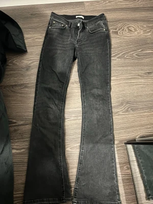Svarta bootcut jeans från Ginatricot  - Säljer ett par svarta bootcut jeans från Ginatricot i storlek 38. Jeansen har klassisk femficksmodell, normalhög midja och utsvängda ben.