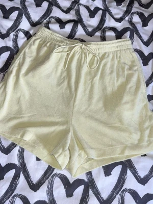Shorts - Ljusgula shorts med elastisk midja och snörning framtill. De har en avslappnad passform, perfekta för varma dagar. Enkla att matcha och superbekväma! Materialet är som froté. Något noppriga men fina att använda ändå.