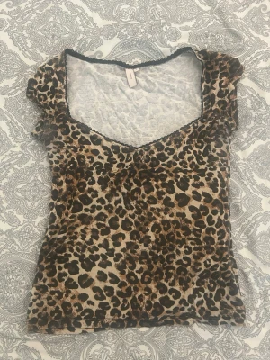 Leopardmönstrad topp med v-ringning - Säljer en leopardmönstrad topp med v-ringning. Har typ aldrig använt den utan bara när jag beställde hem dem men gick ej att skicka tillbaka. 