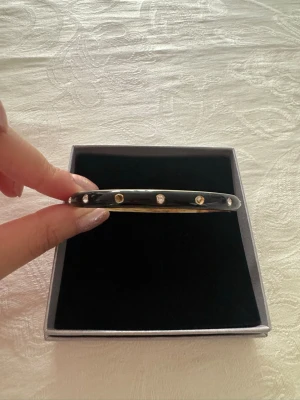 Svart guldigt armband  - Säljs då den tyvärr inte används längre 🙌 tyvärr har 1 1/2 diamant gått av och där man öppnar och stänger armbandet kan vara lite svag men det kan man fixa hemma. Annars finns det inget annat att anmärka om 💕🤗 