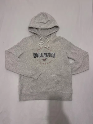 Grå Hollister hoodie  - Grå hoodie från Hollister                    Helt ny och perfekt skick                   Säljer för att den är tyvärr för stor   Sitter som st S