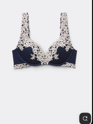 Intimissimi BH - Snygg mörkblå bh med vackra vita spetsdetaljer och blommönster. Superfint skick, använd enstaka gånger.