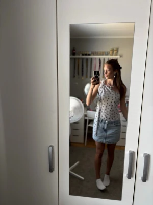 Vit prickig ärmlös linnetopp från H&M - Säljer en söt vit linnetopp med svarta prickar och knytband på axlarna. Toppen är ärmlös och har en avslappnad passform, perfekt för varma dagar. Styla med jeansshorts eller kjol för en fräsch sommarlook! Den är använd jätte få gånger och är i utmärkt skick 
