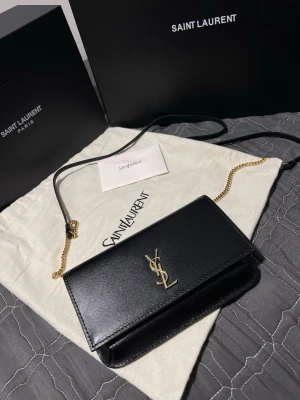 Ysl dam väska  - Säljer den hära fina väskan, Saint Laurent phone Holder köpt under 2025, Serienumret finns i väskan och kan visas för seriösa köpare vid intresse, väskan är behandlad med läderkräm,