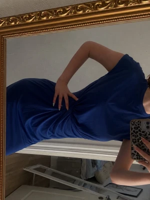 Blå draperad kort klänning - Snygg blå klänning med draperad detalj i midjan och rund halsringning. Modellen är kortärmad och har en kroppsnära passform som framhäver figuren. Helt ny och oanvänd och säljes till ett bra pris . Beställt från företaget JOOM. Finns storlek L i annonsen över denna.