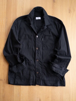 Svart Chore Jacket, studio total - Stilren svart overshirt från studio total i bomull. Klassisk design med tre utanpåliggande fickor, knäppning framtill och avslappnad krage. Perfekt lager-på-lager-plagg med en clean look och raka linjer. Passar till jeans eller chinos för en enkel, snygg stil.