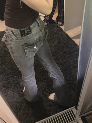 Gråa low rise flare jeans från True Religion - True Religion jeans i kategorin JOEY. storlek W24. Tyvärr lite trasiga längst ner vid byxorna då dom är för långa för mig men det är inget som syns när man har på sig dom 