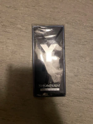 Yves Saint Laurent Y Eau de Toilette - Y Eau de Toilette från Yves Saint Laurent kommer i en stilren svart och silverfärgad rektangulär förpackning med ett stort Y på framsidan. Flaskan rymmer 100 ml och är perfekt för dig som gillar fräscha och moderna dofter.