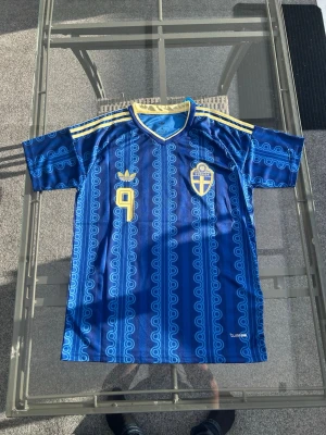 Sverige matchtröja Alexander Isak – Blå & Gul – Stl M - Säljer min Sverige-tröja med Alexander Isak (#9) på ryggen. Riktigt snygg design och skön passform, perfekt inför nästa match eller för en schysst fotbolls-outfit. Tröjan är i storlek M och i fint skick. Säljer den för att den inte används tillräckligt mycket! 🇸🇪  Storlek: M  Skick: Fint skick  Färg: Blå/Gul  Spelare: Alexander Isak Hör av dig om du undrar något eller vill se fler bilder! Kan mötas upp eller skickas spårbart. 