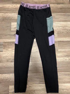 GO ACTIVE träningstights XS – supersköna & stilrena!  - Kappahl GO ACTIVE träningstights i strl XS. Snygga, bekväma och följsamma tights med perfekt passform och sportiga detaljer i lila och mintgrönt. Den breda resåren sitter skönt och ger bra stöd, vilket gör dem perfekta för både träning, promenader och vardagsbruk. Tightsen är i fint begagnat skick och har mycket användning kvar. Ett riktigt snyggt och praktiskt tillskott till träningsgarderoben! 💜🖤✨💪