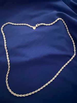 Vridet halsband i silver 925 - Snyggt halsband i silver 925 med tvinnad, vriden kedja. Halsbandet har en klassisk karbinhake och en stilren, glänsande finish. Perfekt accessoar för att lyfta din outfit med en elegant touch.