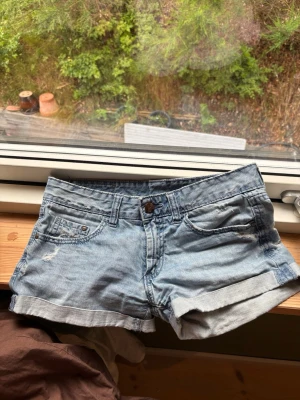 Ljusblå denimshorts med uppvik - Ljusblå denimshorts med uppvikta benslut. Storleken står inte på shortsen men skulle säga att det är xs/34 och säljer för dem är för små. 