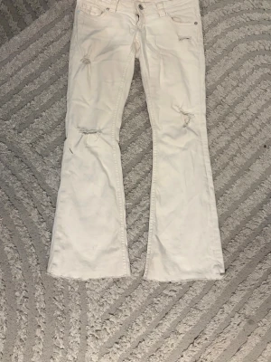 Vita bootcut jeans med slitningar - Säljer ett par vita bootcut jeans med slitningar från Gina Tricot. Säljer dom för att jag aldrig använder dom då jag är rädd för o smutsa ner dom. Orginal pris = 400 kr