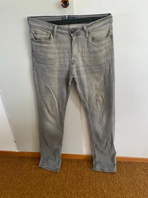 Produkt - Snygga grå slim fit jeans med klassisk femficksdesign och dragkedjegylf. Jeansen har en tvättad look och raka ben, perfekta för en avslappnad och trendig stil. Materialet är mjukt denim som ger en bekväm känsla hela dagen.