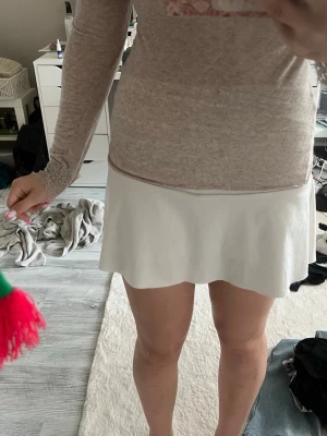 Vit kortkjol från SHEIN - Säljer en vit kortkjol från SHEIN i storlek M. Kjolen har en enkel och stilren design med lätt utsvängd form. Perfekt att matcha med olika toppar för en fräsch look. kjolen har inbyggda shorts också💞 