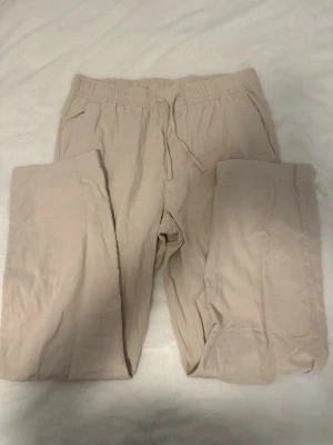 Beige linnebyxa - Beige linnebyxa som har sidofickor fram och två bakfickor. Perfekta för en chill och stilren look. Från lager 157, ej använd.