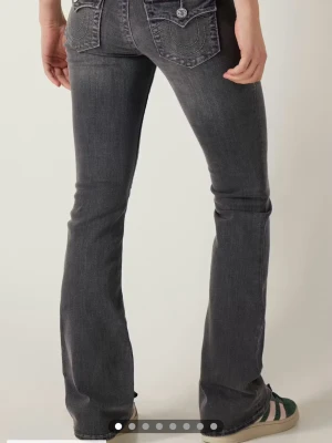 Grå bootcut jeans från True Religion - Säljer ett par grå bootcut jeans från True religion i mid Rise men om man är lite längre passar dom som low waist! Säljer pågrund av att dom är för långa i benen!💕