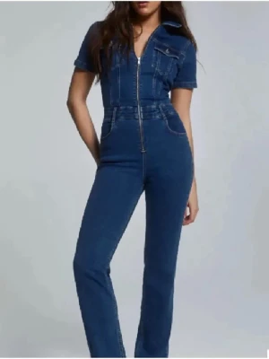 Jeans jumpsuit - Snygg blå denim jumpsuit med dragkedja framtill, korta ärmar och två bröstfickor med knappar. Sitter som en smäck!!😍