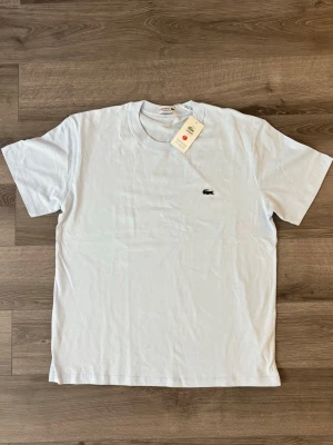❄️Ljusblå Lacoste tshirt❄️ - Klassisk ljusblå lacoste T-shirt med den ikoniska krokodilloggan broderad på bröstet. T-shirten har rund halsringning och korta ärmar. Tillverkad i mjuk bomull för en skön känsla och enkel stil. Storleken är L, passar M eventuellt S. Aldrig använd. Pris kan diskuteras m.