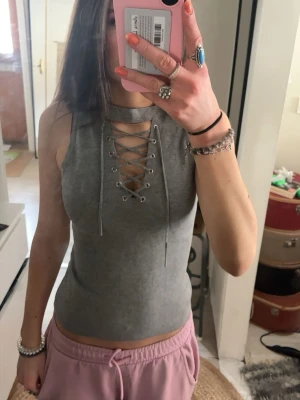 Topp med snörning - Snygg grå ärmlös linnetopp från Lemon med ribbad struktur och cool snörning framtill. Aldrig använd, passar XS/S💕