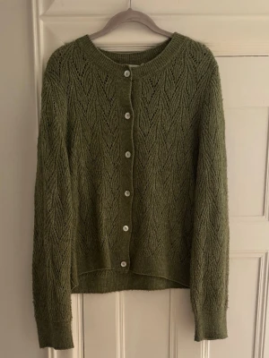 Olivgrön stickad kofta med mönster - Snygg olivgrön stickad kofta. 