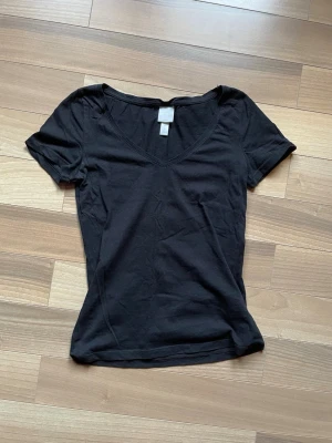 Basic  - Basic svart T-shirt men en fin utdragen v ringning. Knappt använd