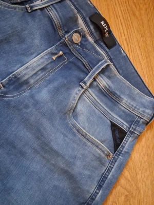 Replay hyperflex blå - Nu är vi ute igen med ett par riktigt snygga jeans från Replay. De är ljusblå och dessutom hyperflex, så riktigt snygga passform. 5 fickor, och en läderlogga på baksidan. Bredd 30 längd 32. Dessa är lite mer premium än våra andra, så vi tänker oss 300, men det är inte hugget i sten, så det är bara att fråga. Hade gött.