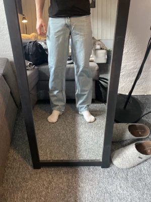 Ljusblå raka jeans - Säljer ett par ljusblå jeans med rak passform och klassisk femficksdesign. Jeansen har normal midja och är tillverkade i denim. Perfekta för en avslappnad och trendig look.