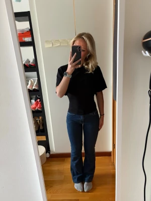 Blå bootcut jeans från Gina Tricot - Säljer ett par klassiska blå bootcut jeans från Gina Tricot. Jeansen har mellanhög midja, fem fickor och raka ben med lätt utsvängning. Materialet är kraftig denim i bomull och passformen är snygg och bekväm. Perfekta för dig som gillar en tidlös look. Jag är 160cm.
