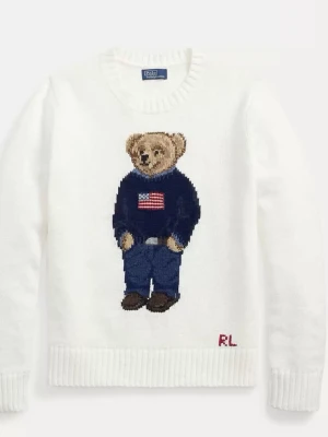 Polo Ralph Lauren - Vit stickad tröja från Polo Ralph Lauren med ikoniskt björnmotiv på bröstet. Björnen har på sig en blå tröja med amerikansk flagga och blå jeans. Tröjan har ribbstickade muddar och rund hals. RL-broderi nertill.