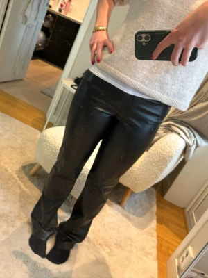 Svarta skinnbyxor med rak passform - Snygga svarta skinnbyxor med rak passform och hög midja. Byxorna har en stilren look och är tillverkade i mjukt skinnmaterial som ger en cool vibe. Perfekta att styla med en enkel topp eller stickad tröja för en trendig outfit. Från Zara