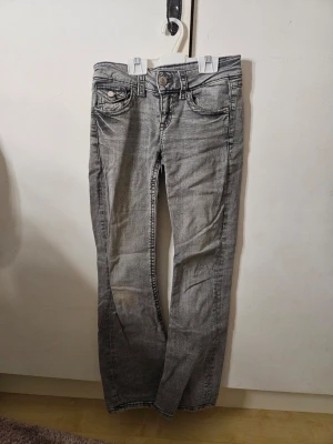 Ljusgrå bootcut jeans från gina tricot - Jag säljer ett par ljusgrå jeans från Gina Tricot i storlek 152. Modellen har låg midja, bootcut-ben, klassiska fem fickor och snygga detaljer på bakfickorna. Jeansen är använda ett fåtal gånger och har därför inga skador förutom ett litet hål som tyvärr blev i en av bakfickorna vid tidig användning, men som jag har sytt ihop själv så att det nu ser ut som en fin detalj istället, och en svag fläck på ena känt. (Se bilder) Nypris runt 300 kr. 💓