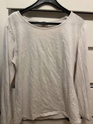 Vit långärmad topp i bomull - En enkel och stilren vit långärmad topp med rund halsringning. Tillverkad i mjuk bomull, perfekt att matcha med jeans eller kjol för en clean look. Passar dig som gillar basic plagg med avslappnad känsla.