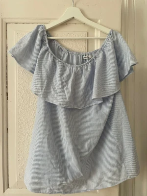 Blåvit offshoulder sommarklänning - Söt blåvit randig offshoulder tröja med volang upptill. I märket miss mille
