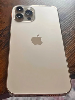 iPhone 12 Pro Max guld - Snygg iPhone 12 Pro Max 128gb i guld med elegant glasbaksida och rostfria kanter. Telefonen har tre kameror på baksidan och en stor, skarp skärm på framsidan. Klassisk Apple-design med rundade hörn och stilren känsla. Perfekt för dig som gillar premiumkänsla och kraftfull prestanda. Batterikapacitet 87%.