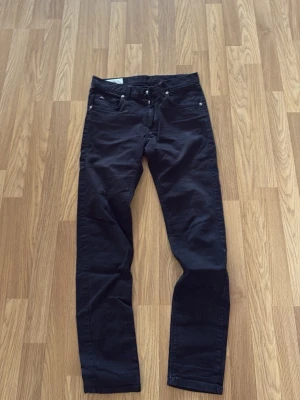 Svarta slim fit jeans - Snygga svarta jeans i slim fit-modell med klassisk femficksdesign och silverfärgade nitar. Jeansen har normal midja och raka ben. Perfekta till en avslappnad streetwear-look eller att matcha med en hoodie.