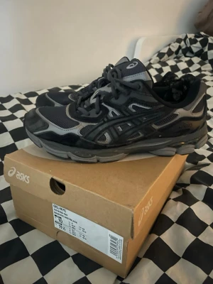 Asics GEL-NYC  - Säljer ett par Asics GEL-NYC sneakers i färgen graphite grey/black. Skorna har en chunky sula, mesh- och mockadetaljer samt klassiska Asics-stripes på sidan. Perfekta för dig som gillar streetwear och sportig stil.