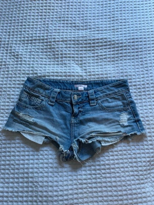 Blå jeansshorts med fina detaljer - Säljer ett par ljusblå jeansshorts med fina detaljer. Knappt använda.