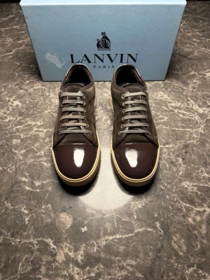 Lanvin - Säljer ett par otroligt snygga skor från det exklusiva märket Lanvin! Skorna är nästan i helt nytt skick, skulle säga ungefär 9,8/10. Nypris ligger på över 4500 kronor men vi säljer våra för endast 2299 och kan gå ner i pris ännu mer vid snabb affär! Skorna är i storlek UK 9 vilket motsvarar ungefär 43 eu. Skriv gärna ifall det är några funderingar, allt bästa SkoKapet