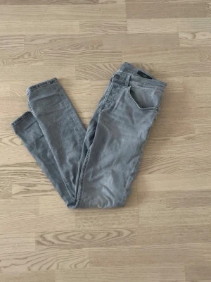 DONDUP George jeans - Jeansen är i fint skick och har en snygg grå tvätt som passar till det mesta. Modell George med bekväm passform och hög kvalitet. Snabb leverans efter köp! 📦Har du några frågor eller vill ha fler bilder är det bara att höra av dig. 😊
