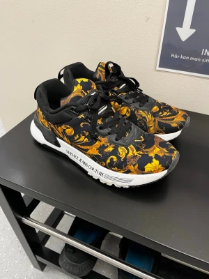 Versace skor - Snygga sneakers från Versace Jeans Couture, ny pris cirka 2500kr, storlek 41, skick 9/10. Extremt  sköna. Pris kan diskuteras lite vid snabb affär! Skorna går självklart att knyta upp själv. Perfekt för dig som vill sticka ut med lyx!