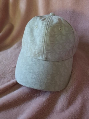 Calvin Klein keps - 6 Panel Baseball Unisex - Chateau - Säljer en jättefin och stilren keps från Calvin Klein Jeans i modellen "6 Panel Baseball" (Unisex). Färgen heter Chateau och har ett snyggt, subtilt monogram-mönster över hela kepsen.
