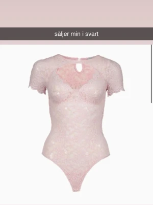 Svart spetsbody med kort ärm - Säljer en svart body i spets med korta ärmar och halsringning. Bodyn har ett fint hål vid bröstet och vackra spetsdetaljer över hela plagget. Perfekt för dig som vill ha något extra snyggt.