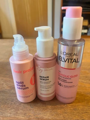 Hair care kit  - Säljer tre olika hårserum: L'Oréal Paris Elvital Glycolic Gloss Leave-In Serum 150 ml, The Hair Project Split Ends Serum och By Veira Repair Serum. Alla kommer i snygga rosa flaskor med pump, perfekta för att ge glans och vård till håret.