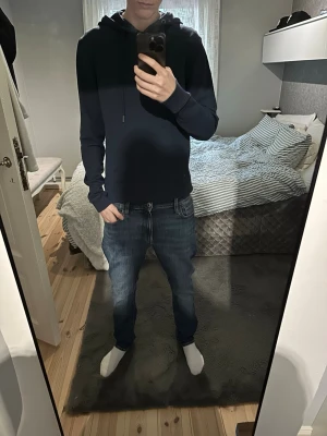 Mörkblå hoodie från Bread & Boxers  - En stilren mörkblå hoodie med huva. Hoodien har långa ärmar, ribbade muddar och en klassisk passform. Perfekt för en avslappnad look och enkel att matcha med jeans eller joggers.