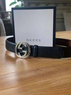 ÄKTA!!! GG bälte. GUCCI - Snyggt svart skärp från Gucci med klassiskt silverfärgat GG-spänne. Skärpet är gjort i präglat skinn och har en stilren design som passar till allt. Insidan är i ljust läder och detaljerna är riktigt lyxiga.
